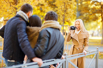 Image showing group of friends with photo camera in autumn park