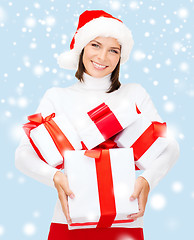 Image showing woman in santa helper hat with many gift boxes