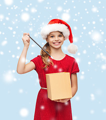 Image showing smiling girl in santa helper hat with gift box