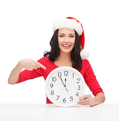 Image showing woman in santa helper hat with clock showing 12