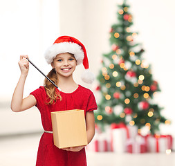 Image showing smiling girl in santa helper hat with gift box