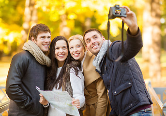 Image showing group of friends with photo camera in autumn park