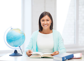 Image showing teacher with globe and book at school