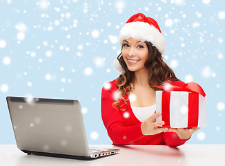Image showing woman with gift box and laptop computer