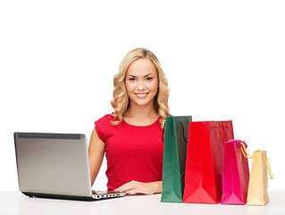 Image showing woman with shopping bags and laptop computer