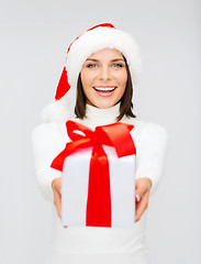 Image showing smiling woman in santa helper hat with gift box