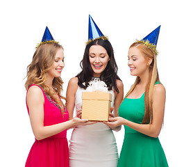 Image showing three smiling women in blue hats with gift box