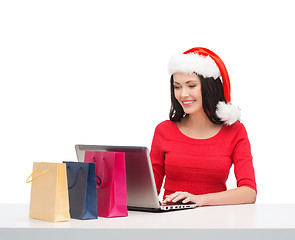 Image showing woman with shopping bags and laptop computer