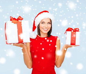 Image showing woman in santa helper hat with many gift boxes