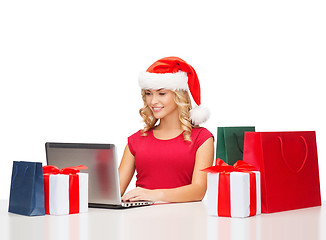 Image showing woman with gift boxes, bags and laptop computer