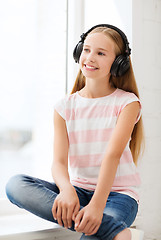 Image showing little girl with headphones at home