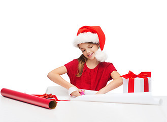 Image showing smiling girl in santa helper hat with gift box