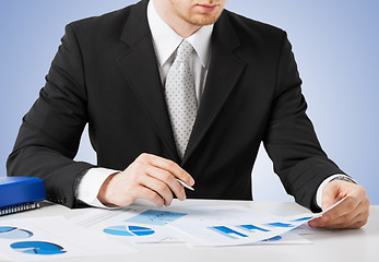 Image showing businessman working and signing with papers