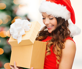 Image showing smiling woman in santa helper hat with gift box