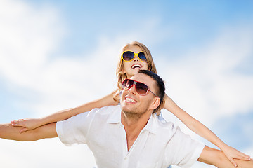 Image showing happy father and child in sunglasses over blue sky