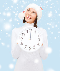 Image showing woman in santa helper hat with clock showing 12