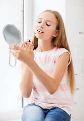 Image showing teenage girl with lip gloss and mirror