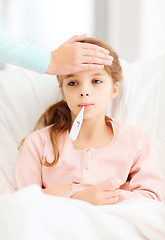 Image showing ill girl child with thermometer and caring mother