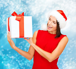 Image showing smiling woman in santa helper hat with gift box