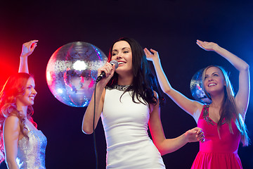 Image showing three smiling women dancing and singing karaoke