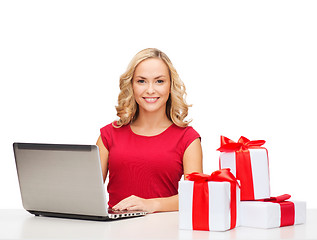 Image showing woman with gift boxes and laptop computer