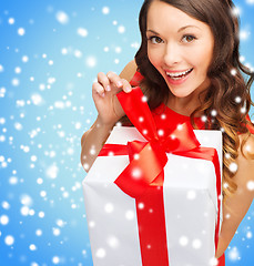 Image showing smiling woman in red dress with gift box