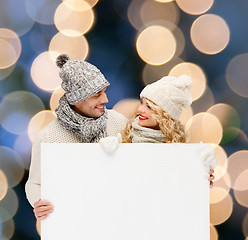 Image showing couple in winter clothes with blank white board