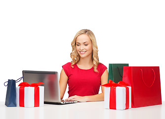 Image showing woman with gift boxes, bags and laptop computer