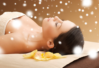 Image showing woman in spa salon lying on the massage desk