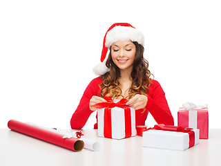 Image showing smiling woman in santa helper hat with gift box