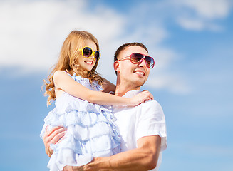 Image showing happy father and child in sunglasses over blue sky