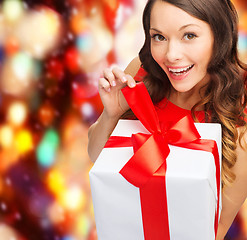 Image showing smiling woman in red dress with gift box