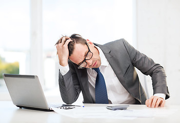 Image showing businessman with computer, papers and calculator