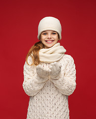 Image showing girl in winter clothes with something on palms