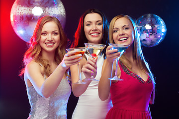 Image showing three smiling women with cocktails and disco ball