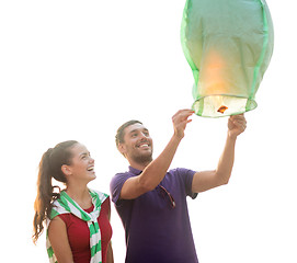 Image showing couple with chinese sky lanterns on the beach