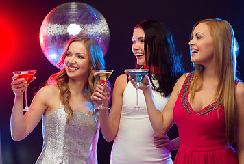 Image showing three smiling women with cocktails and disco ball