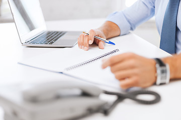 Image showing businessman writing in notebook