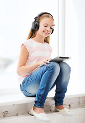 Image showing girl with tablet pc and headphones at home