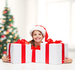 Image showing girl in santa helper hat with many gift boxes