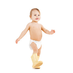 Image showing cute little boy walking in big rubber boots