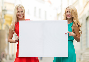 Image showing two happy blonde women with blank white board