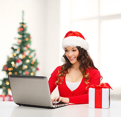 Image showing woman with gift box and laptop computer