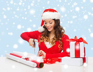 Image showing smiling woman in santa helper hat with gift box