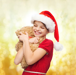 Image showing smiling girl in santa helper hat with teddy bear