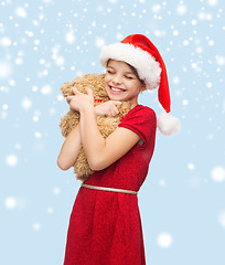 Image showing smiling girl in santa helper hat with teddy bear