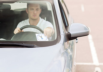 Image showing man placing parking clock on car dashboard