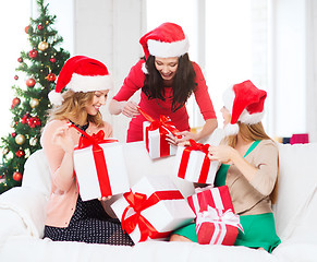 Image showing women in santa helper hats with many gift boxes