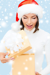 Image showing surprised woman in santa helper hat with gift box