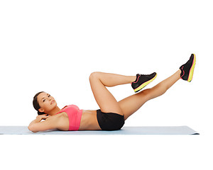 Image showing sporty woman doing exercise on the floor